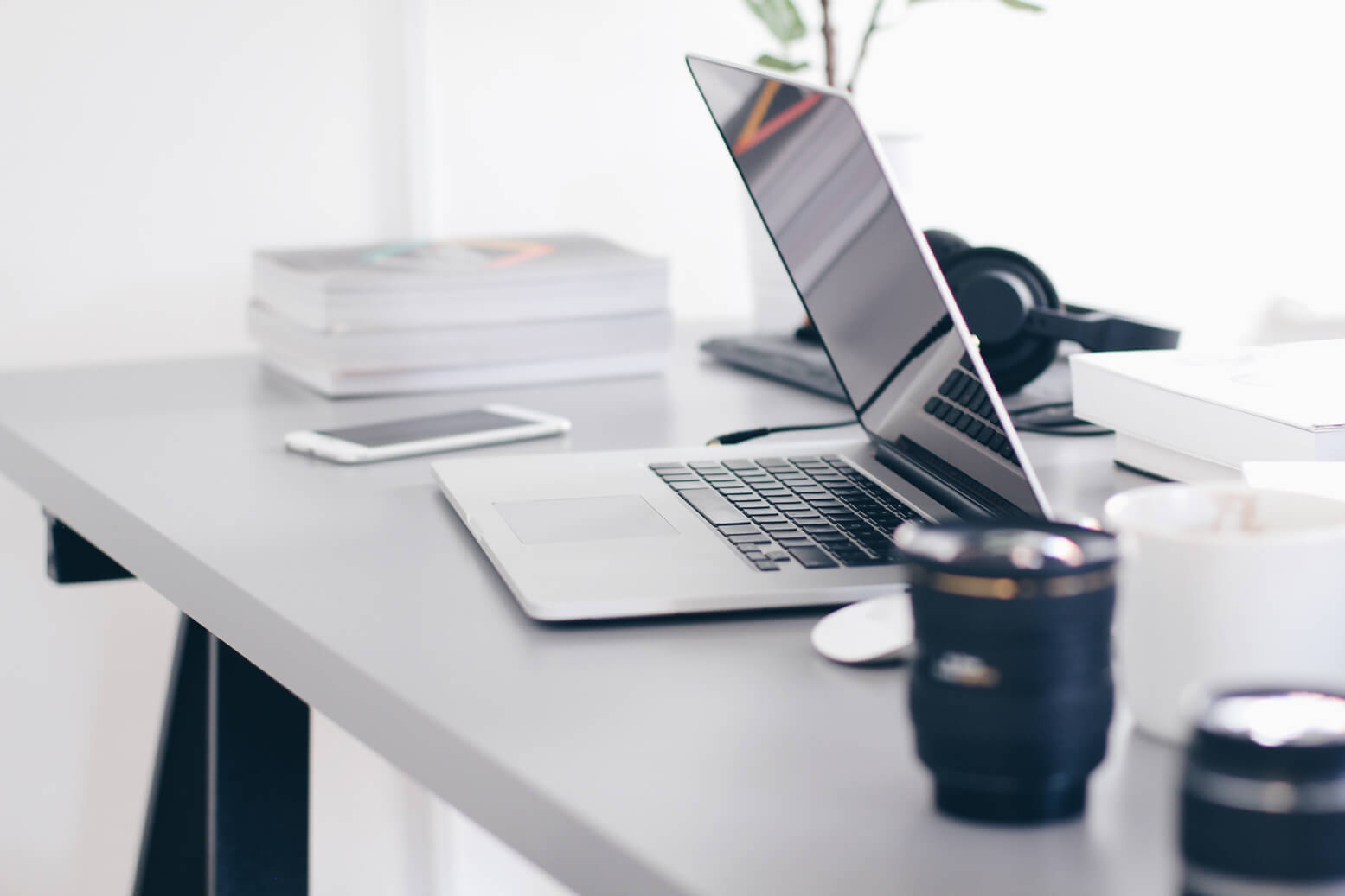 silver macbook pro on white table with coffee mug