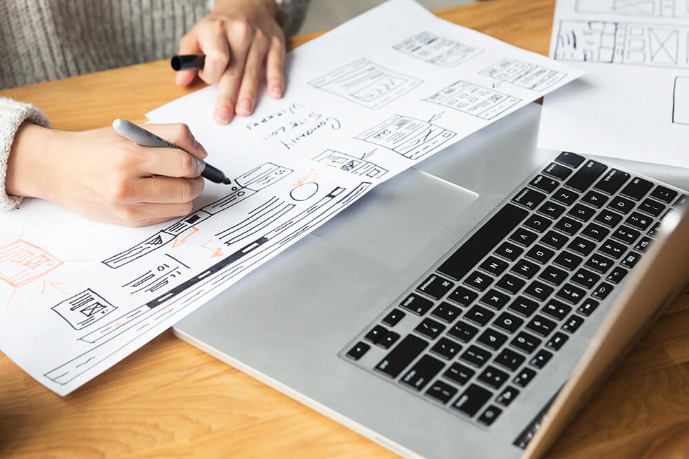 Designer drawing a website mockup. This will help improve your website.